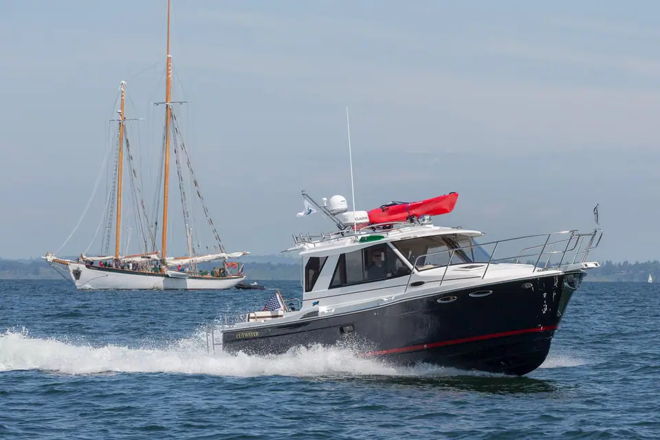 Cutwater C28 running at speed with a schooner sailing behind