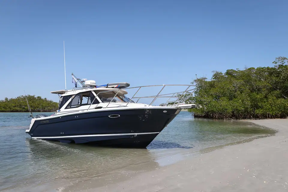 Cutwater C248 Coupe nosed onto a sandy beach beside mangroves