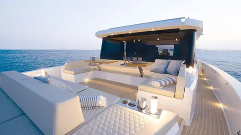 De Antonio D60 bow lounge with sunpad and tables looking aft toward the coupe top