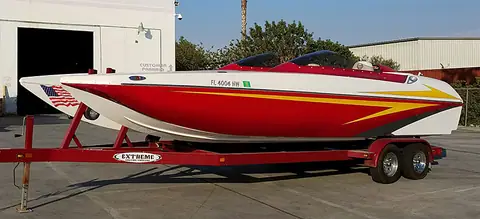 Eliminator 25 Daytona in profile on its trailer with red, yellow and white graphics