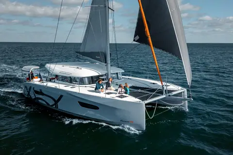Excess 14 catamaran under sail seen from the bow quarter on a calm sea
