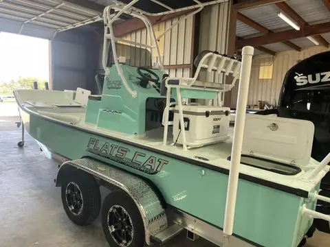 Flats Cat 21 with a seafoam hull on its trailer showing the console, leaning post and T top