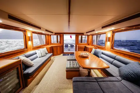 Fleming 65 main saloon with teak joinery, sofas and a coffee table