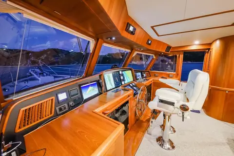 Fleming 65 pilothouse helm with wheel, helm chair and navigation screens