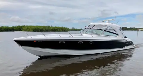 Formula 400 Super Sport with a black hull idling in profile on a calm river