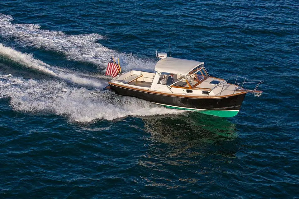 Fortier 26 at speed seen from the bow quarter with varnished trim