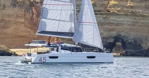 Fountaine Pajot Elba 45 under sail in front of sandstone cliffs