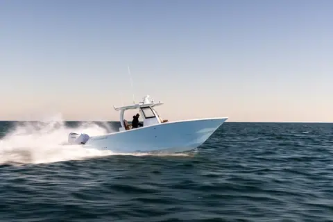 Freeman 29 running at speed with a pale blue hull and a hardtop