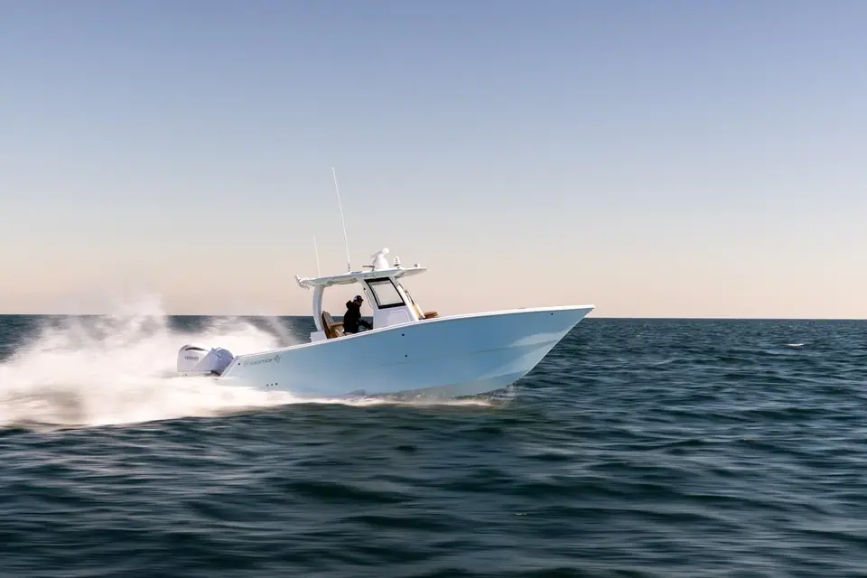 Freeman 29 running at speed with a pale blue hull and a hardtop