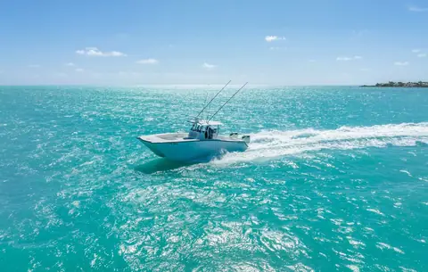 Freeman 34VH cruising across shallow turquoise water with rods in the hardtop