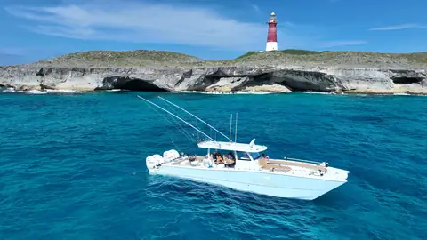 Freeman 47 at anchor in clear Bahamas water below a lighthouse