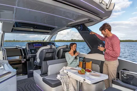 Cockpit of the Galeon 325 GTO with guests at the dinette under the hardtop