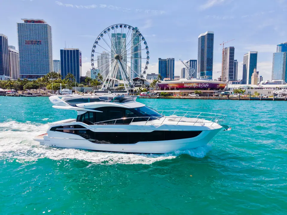 Galeon 440 Fly cruising off the Miami skyline with its dark hull windows and flybridge