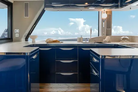 Galley of the Galeon 640 Fly with dark blue cabinetry and large windows