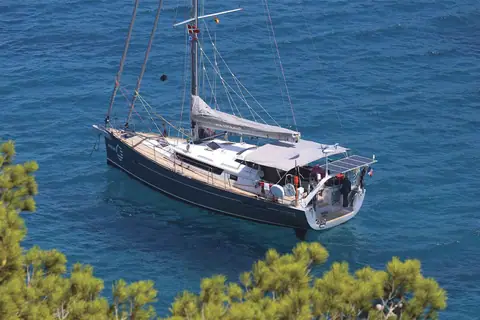 Garcia Exploration 45 at anchor in clear blue water seen from a wooded shore