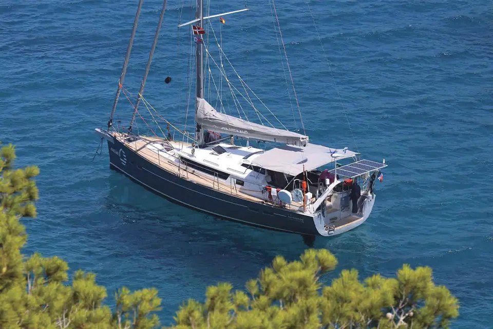 Garcia Exploration 45 at anchor in clear blue water seen from a wooded shore