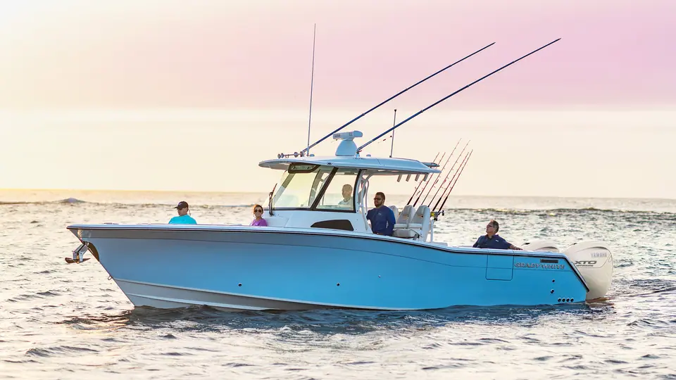 Grady-White Canyon 336 cruising at sunset with a family aboard and outriggers raised
