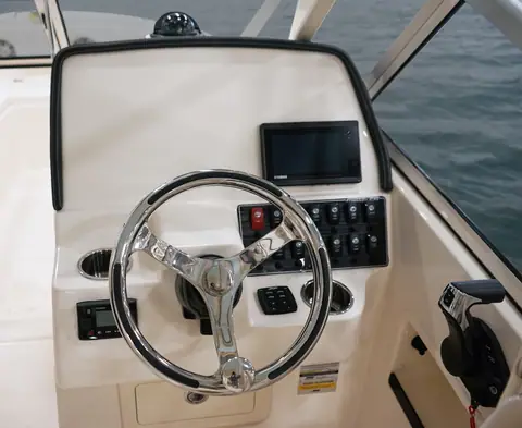 Helm of the Grady-White Freedom 235 with stainless wheel, display and switch panel