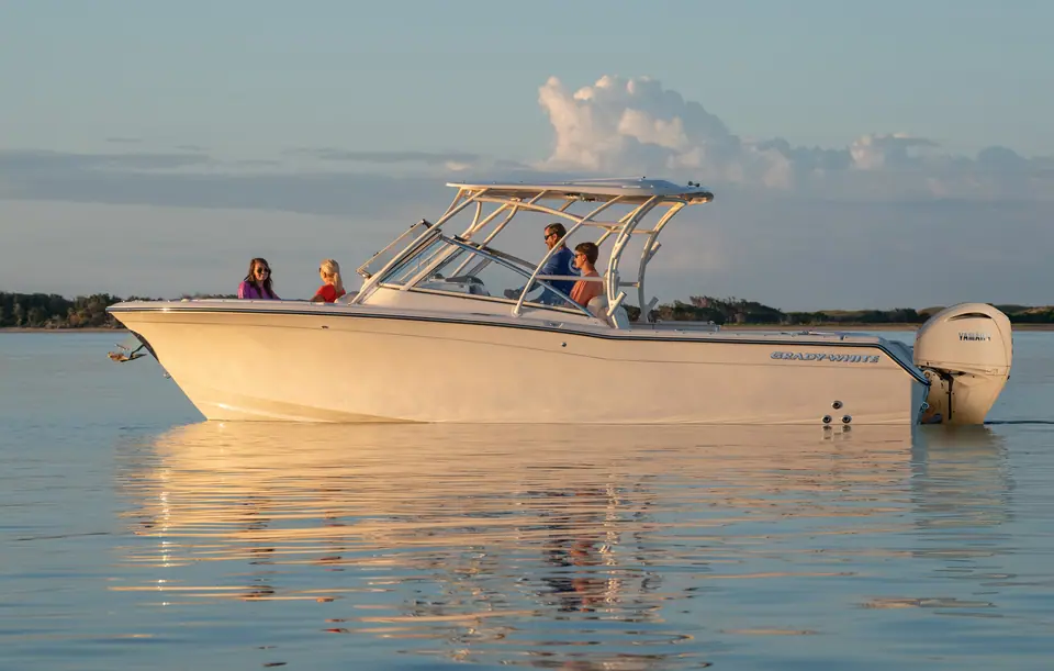 Grady-White Freedom 275 at rest on calm water at sunset with guests aboard