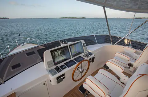 Grand Banks 60 flybridge helm with twin displays, a wooden wheel and white helm seats