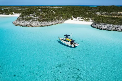 Aerial view of a Grand Banks 32 anchored in clear turquoise water off a Bahamas island