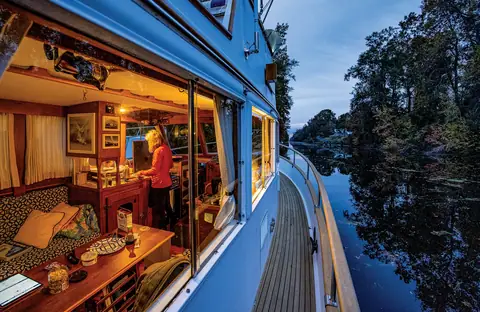 Warmly lit saloon of a Grand Banks 32 seen through the side window at dusk