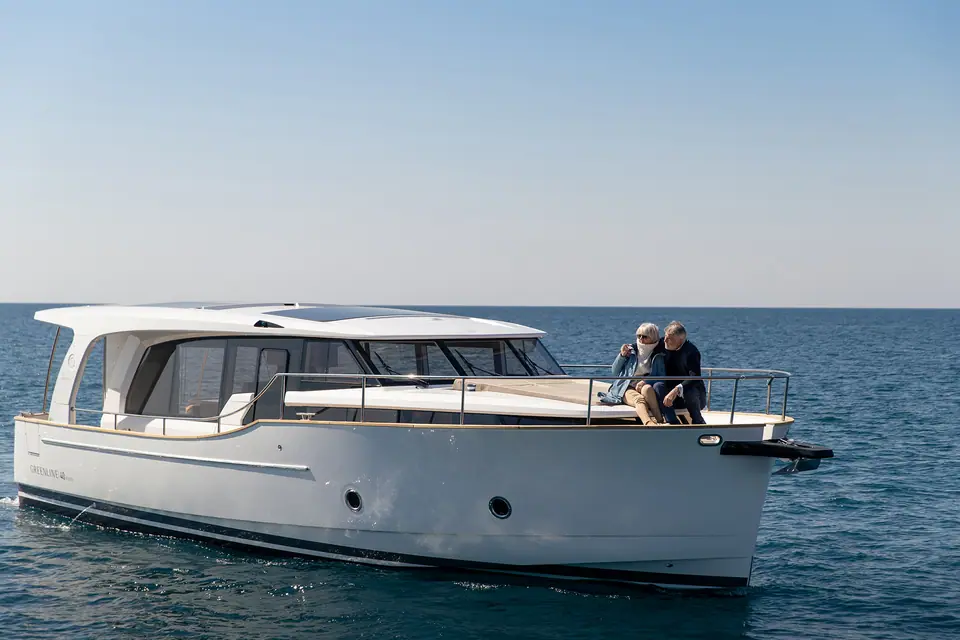 Greenline 40 cruising slowly with a couple seated on the foredeck