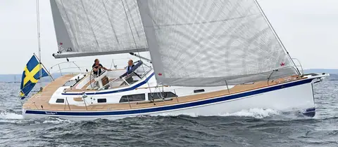 Hallberg-Rassy 44 sailing upwind under main and genoa with two crew in the cockpit