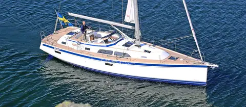 Elevated view of the Hallberg-Rassy 44 under power with the blue hull stripe and teak decks