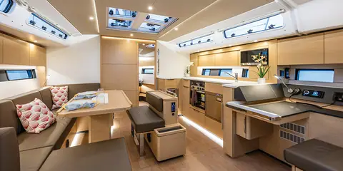 Hanse 460 saloon with an L shaped settee, dinette table and linear galley under deck hatches