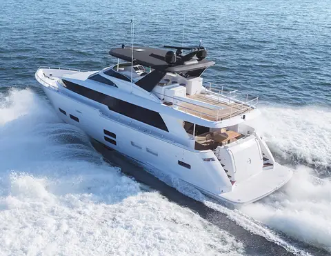 Elevated stern quarter view of the Hatteras 70 Motor Yacht underway showing the aft deck and flybridge