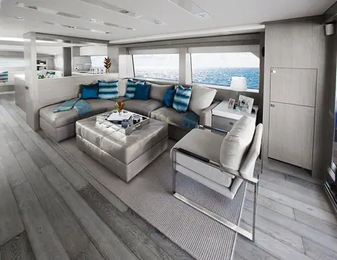 Hatteras 70 Motor Yacht main salon with a gray sectional sofa and large side windows