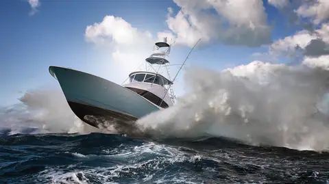 Hatteras GT59 launching off a wave with spray flying
