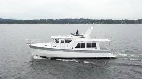 Helmsman Trawlers 43E Pilothouse cruising in profile on a lake with its flybridge and mast