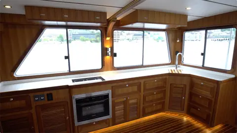 Helmsman 43E Pilothouse galley with teak cabinets, a white counter and a wall oven