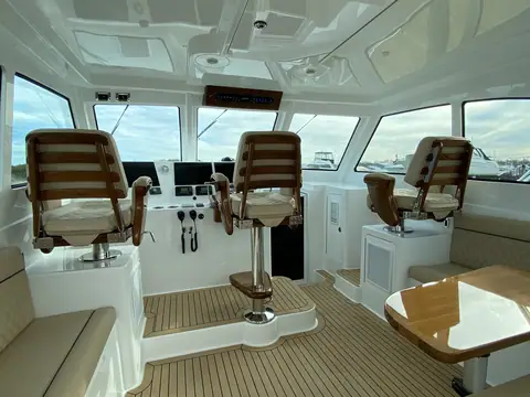 Henriques 42 Express Hardtop enclosed helm deck with three teak helm chairs and a dinette
