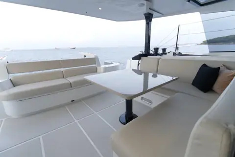 HH44 aft cockpit with wraparound cream settees and a table under the hardtop