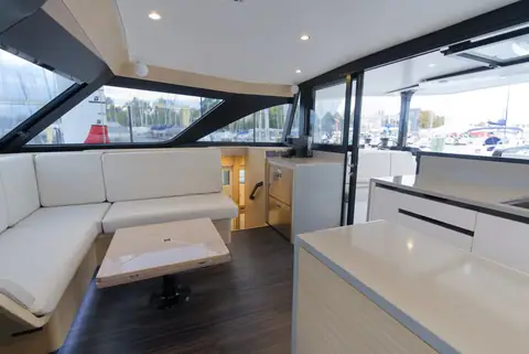 HH44 saloon with an L shaped settee, table and galley counter under wraparound windows
