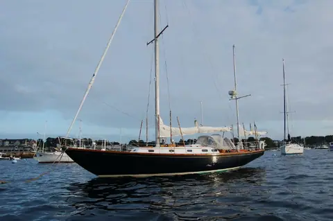 Hinckley Bermuda 40 yawl with a black hull and covered sails at anchor