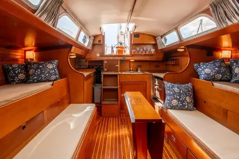 Hinckley Bermuda 40 saloon with varnished wood, settee berths and a drop leaf table