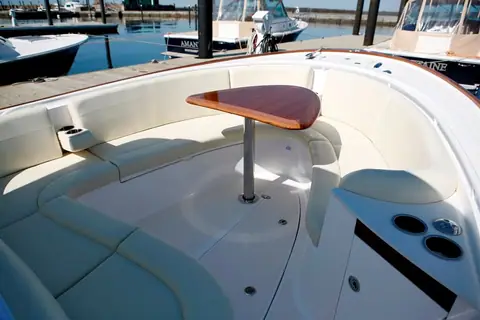Hunt 32 Center Console bow seating with cream cushions and a teak table