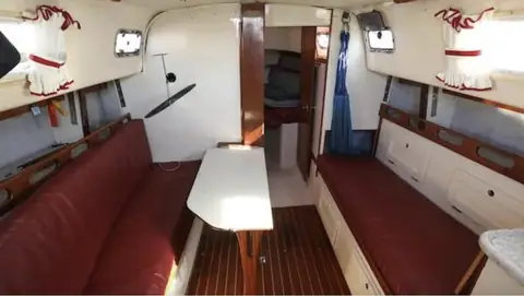 Hunter 30 saloon with red settees, a folding table and the forward cabin door