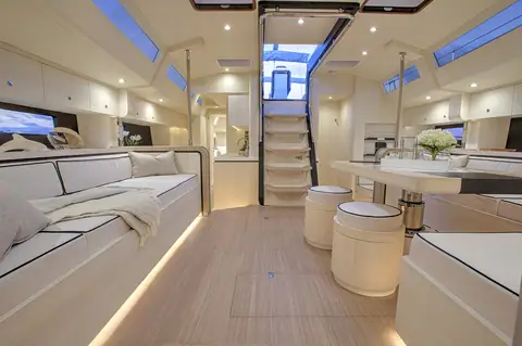 Hylas H60 main saloon with settees, dining table and companionway steps
