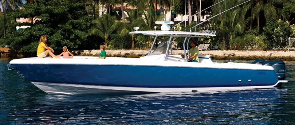 Intrepid 400 Center Console idling in profile near a palm lined shore with guests on the bow
