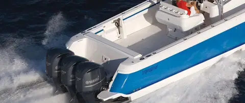 Intrepid 400 Center Console cockpit and triple Yamaha outboards seen from astern under way