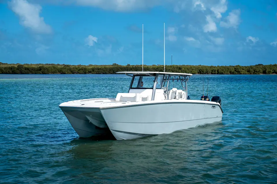 Invincible 40 Catamaran idling in shallow water showing its twin hulls