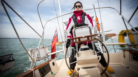 Island Packet 380 cockpit with a sailor at the wheel and the pedestal binnacle