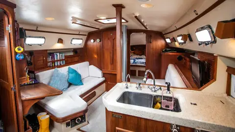 Island Packet 380 saloon with teak joinery, L shaped settee and galley sink