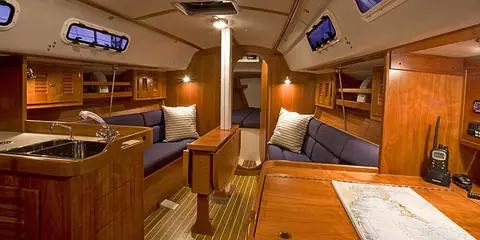 J/109 saloon with cherry joinery, blue settees and the galley to port