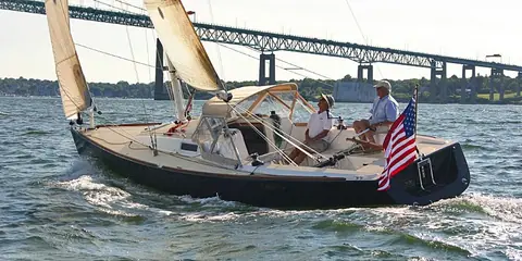 J/100 reaching with two people relaxing in the long cockpit under a bridge
